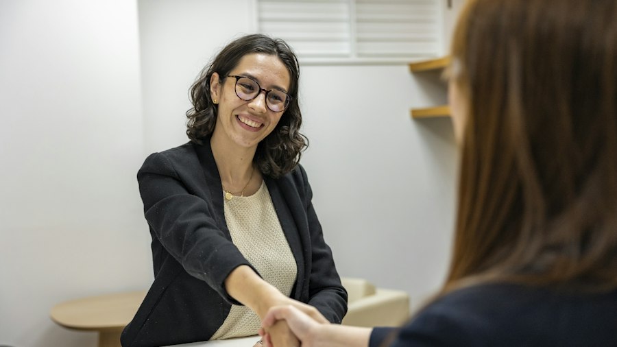 Two women shaking hands in an office